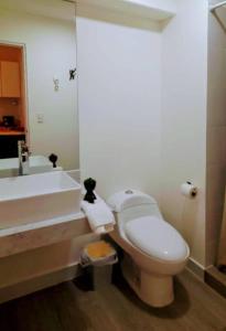 a bathroom with a toilet and a sink and a tub at Colorfull Studio in Barranco in Lima