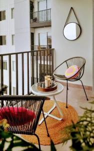 Un balcón con 2 sillas y una mesa con una taza de café. en Colorfull Studio in Barranco, en Lima