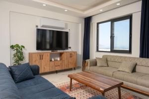 a living room with a couch and a flat screen tv at Villa Arna ELİTE in Demre