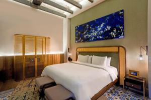 a bedroom with a large bed and a painting on the wall at Casona 142 Orizaba, Part of Curamoria Collection in Orizaba