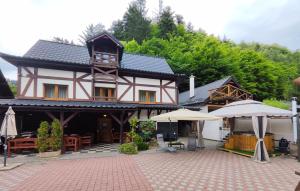 a large building with tables and umbrellas in front of it at Chata Gatterhof in Banská Štiavnica