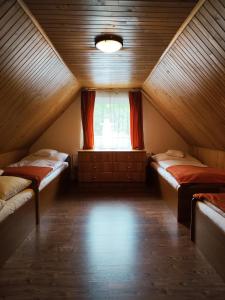 a attic room with two beds and a window at Chata Gatterhof in Banská Štiavnica