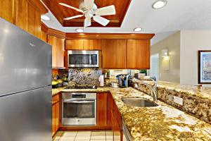 a kitchen with a sink and a refrigerator at Hololani A203 in Kahana +20 photos