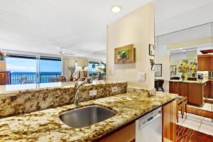 a kitchen with a sink and a large window at Hololani A203 in Kahana