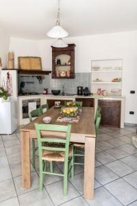 uma cozinha com uma mesa de madeira e cadeiras verdes em Nel cuore del centro storico di Maratea em Maratea