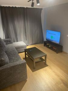 a living room with a couch and a table and a tv at Lasma’s hub in Jelgava