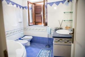 uma casa de banho azul e branca com um WC e um lavatório em Nel cuore del centro storico di Maratea em Maratea