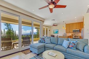 a living room with a blue couch and a kitchen at Kapalua Golf Villa 27V 3 in Kahana