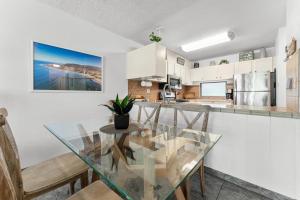 a kitchen and dining room with a glass table and chairs at Kihei Akahi B102 in Wailea