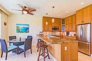 Una cocina con gabinetes de madera y una mesa y sillas. en Kapalua Golf Villa 27V 3, en Kapalua 31 fotos más