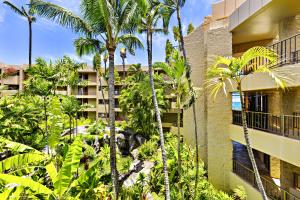 a building with palm trees in front of it at Paki Maui 319 in Honokowai