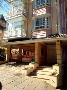 uma grande casa com um alpendre e um pátio em Apartamento Solar da Borges em Gramado