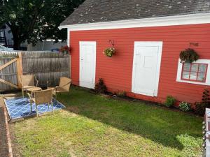 una casa roja con una mesa y sillas en un patio en Sunny One Bedroom in Historic Downtown Dover, en Dover