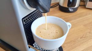 a person is pouring a coffee into a cup at Wohnung: Beast. Bis 6 Personen, Klima, Massageliege, 3x TV in Cremlingen