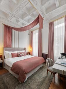 1 dormitorio con 1 cama grande y cortinas rojas en Mr Cas Hotels Taksim - Special Category, en Estambul