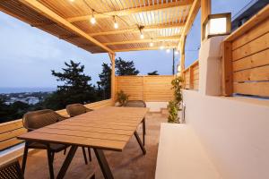 an outdoor patio with a wooden table and chairs at Sevasti Seaview Suite in Koskinou