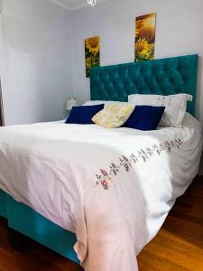 a bedroom with a large bed with a blue headboard at Depto Metro Plaza de Armas (1 dormitorio 1 baño) in Santiago