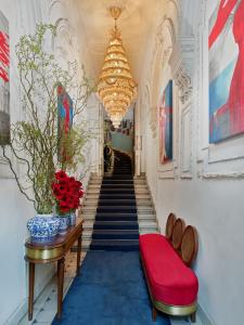 a hallway with stairs with a red bench and a chandelier at Mr Cas Hotels Taksim - Special Category in Istanbul