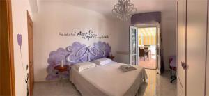 una camera da letto con un letto dipinto di viola sul muro di Ponza Le Forna a Ponza