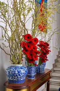 two blue and white vases with red flowers on a table at Mr Cas Hotels Taksim - Special Category in Istanbul