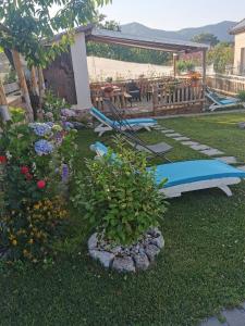 a garden with benches and a table and a surfboard at Astra in Agerola
