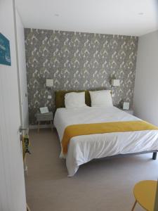 a bedroom with a large bed with a wall at 12 pers, sur la dune, PMR, spa, hammam, salle de sport in Barbâtre