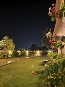 un jardín por la noche con luces en el fondo en Param Country Home and Pool en Jalandhar