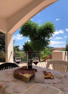 una mesa con una botella de vino y dos copas en Appartamento MareMontagna, en Cardedu