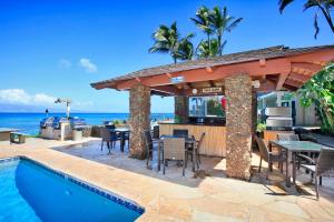 a patio with a bar and a swimming pool at Noelani 104 in Kahana
