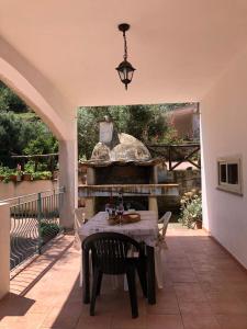 un patio con una mesa y una parrilla al aire libre en Appartamento MareMontagna, en Cardedu