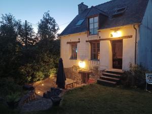 Biały dom z oświetleniem przed nim w obiekcie Cottage Breton w mieście Les Champs-Géraux