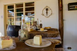 a table with cheese and wine bottles on it at Pousada Vale das Primaveras in Três Corações
