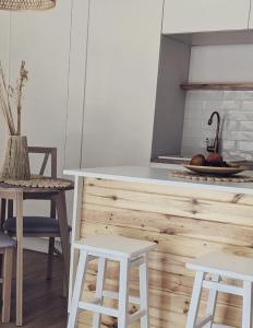 eine Küche mit zwei weißen Stühlen und einer Theke in der Unterkunft Apartament&SPA Lis&Las in Sobótka