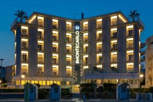 a hotel with a sign in front of it at Hotel Montecarlo in Caorle