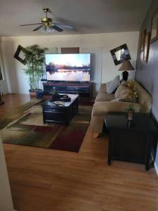 sala de estar con sofá y TV de pantalla plana en R&R in Saguaro Natl Park, en Avra