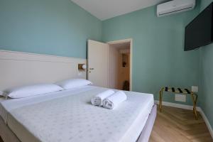 1 dormitorio con 1 cama con 2 toallas en CAMERANOAPARTMENTS - L'ANGOLO DELLA PIAZZA, en Camerano
