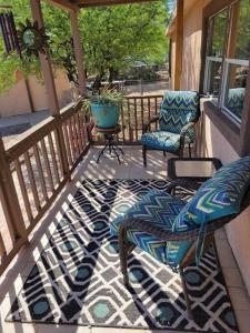 un porche con 2 sillas y una mesa en una terraza en R&R in Saguaro Natl Park, en Avra