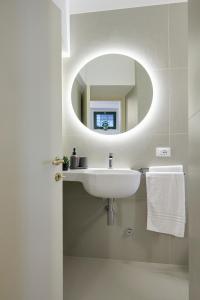卡梅拉諾的住宿－CAMERANOAPARTMENTS - L'ANGOLO DELLA PIAZZA，一间带水槽和镜子的浴室