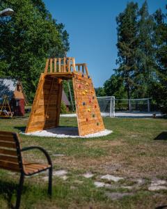 een speeltuin met een houten klimrek in een park bij Kemp Sluníčko in Doksy