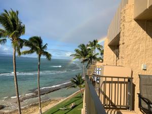 a balcony with a view of the ocean and palm trees at Paki Maui 405 in Honokowai