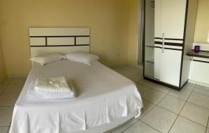 a white bed with two pillows on it in a room at HOTEL AVENIDA in Alta Floresta