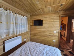 Kleines Zimmer mit einem Bett und einem Fenster in der Unterkunft WHITE HOUSE, Vidraru in Căpăţîneni-Pămînteni