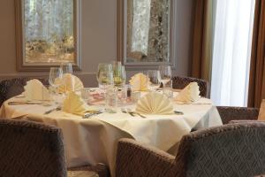 einen Tisch mit Weingläsern und Servietten darauf in der Unterkunft Hotel Restaurant Post in Bözen