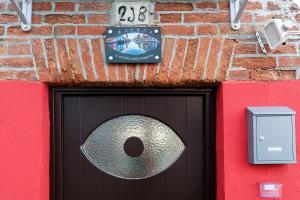 een zwarte deur met een bord op een stenen muur bij Burano L' Occhio sulla Laguna in Burano