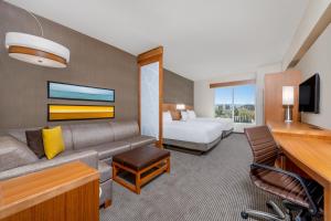 une chambre d'hôtel avec un canapé et un lit dans l'établissement Hyatt Place San Jose Airport, à San José