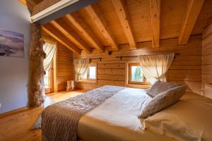 a bedroom with a bed in a log cabin at Rifugio de Dòo in San Niccolò Comèlico