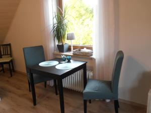 mesa, 2 sillas, mesa y ventana en Fewo Auszeit 1, en Harschbach