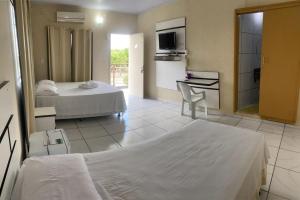 a hotel room with two beds and a kitchen at HOTEL AVENIDA in Alta Floresta