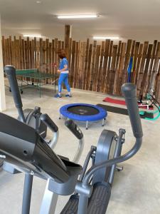 a woman playing ping pong in a gym with a ping pong table at Ferienwohnung im Chaletstil Schlossblick 51 qm Wellness Fitness Sauna Bergrödelhof in Feilitzsch
