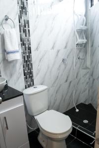 a white bathroom with a toilet and a sink at Hostal Lucas Corferias - Habitaciones Privadas in Bogotá